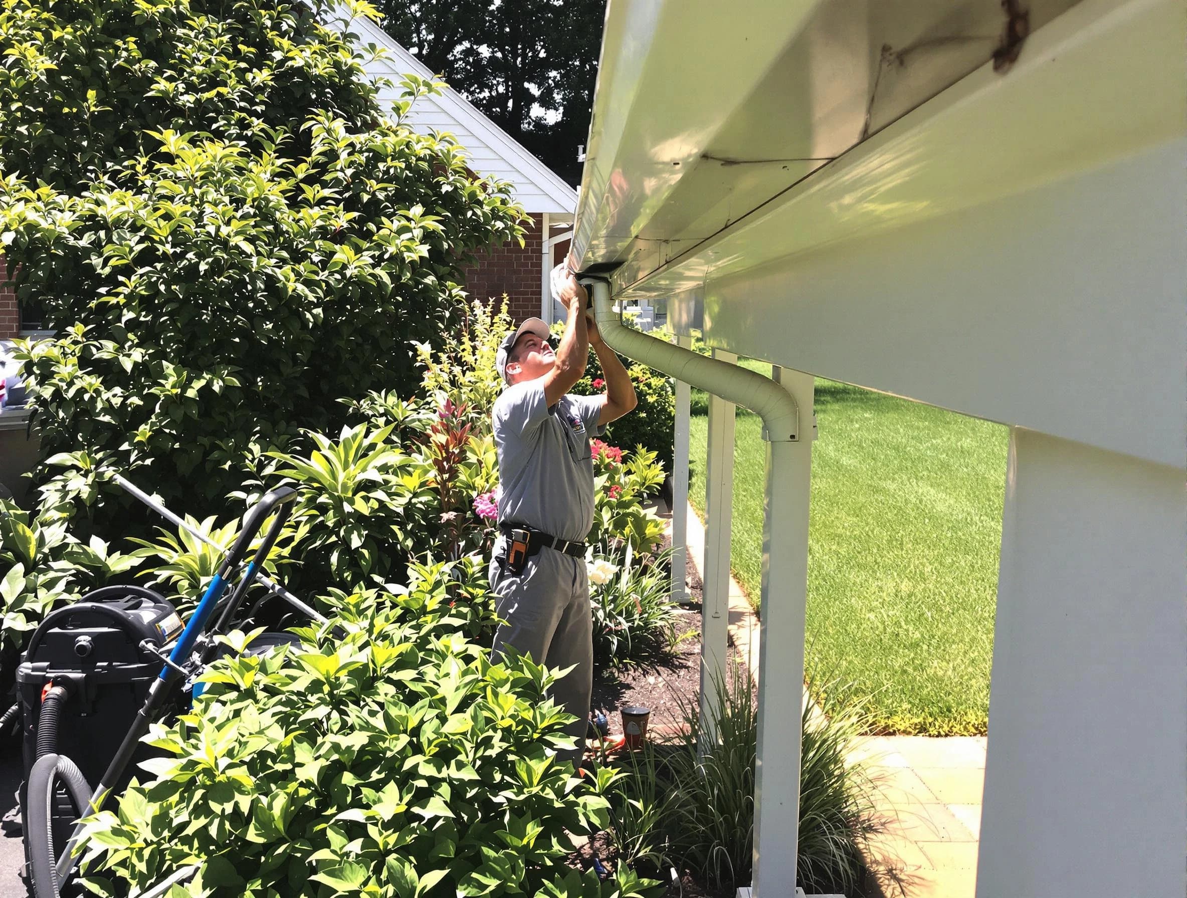 Technician flushing a blockage from a downspout in Brecksville, OH